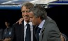 Manchester City's coach Roberto Mancini of Italy is embraced by Real Madrid coach Jose Mourinho from Portugal before a Champions League Group D soccer match at the Santiago Bernabeu Stadium, in Madrid, Tuesday, Sept. 18, 2012. (AP Photo/Daniel Ochoa De Olza)