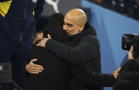 Manchester City's head coach Pep Guardiola, right, meets Arsenal's manager Mikel Arteta before the English FA Cup 4th round soccer match between Manchester City and Arsenal at the Etihad Stadium in Manchester, England, Friday, Jan. 27, 2023. (AP Photo/Dave Thompson)
