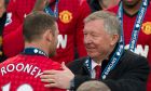 Manchester United's manager Sir Alex Ferguson, right, speaks to striker Wayne Rooney after his last home game in charge of the club, their English Premier League soccer match against Swansea City, at Old Trafford Stadium, Manchester, England, Sunday May 12, 2013. (AP Photo/Jon Super)  
