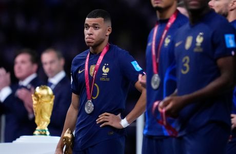 France's Kylian Mbappe holds the Golden Boot award for top goal scorer of the tournament during the awards ceremony after Argentina defeated France in the World Cup final soccer match at the Lusail Stadium in Lusail, Qatar, Sunday, Dec. 18, 2022. (AP Photo/Natacha Pisarenko)