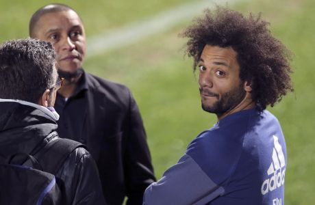 Real Madrid's Marcelo, right, talks with former Brazil national soccer team player Roberto Carlos, center, during a training session at the FIFA Club World Cup soccer tournament in Yokohama, near Tokyo, Tuesday, Dec. 13, 2016. Real Madrid and Club America will play in the Dec. 15 semifinal. (AP Photo/Shizuo Kambayashi)