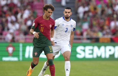 Portugal's Joao Felix, left, challenges for the ball with Bosnia's Adrian Leon Barisic during the Euro 2024 group J qualifying soccer match between Portugal and Bosnia and Herzegovina, at the Luz Stadium in Lisbon, Portugal, Saturday, June 17, 2023. (AP Photo/Armando Franca)