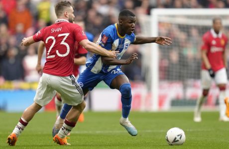 Brighton's Moises Caicedo is challenged by Manchester United's Luke Shaw, left, during the English FA Cup semifinal soccer match between Brighton and Hove Albion and Manchester United at Wembley Stadium in London, Sunday, April 23, 2023. (AP Photo/Kirsty Wigglesworth)