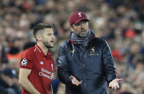 Liverpool coach Juergen Klopp, right speaks to his player Liverpool midfielder Adam Lallana who is about to come on as a substitute during the Champions League group C soccer match between Liverpool and Red Star at Anfield stadium in Liverpool, England, Wednesday, Oct. 24,2018.(AP Photo/Jon Super)