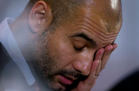 Bayern's head coach Pep Guardiola wipes his face during a press conference in Manchester, England, Monday, Nov. 24, 2014. Bayern Munich will play Manchester City on Tuesday in a Champions League Group E soccer match. (AP Photo/Jon Super)