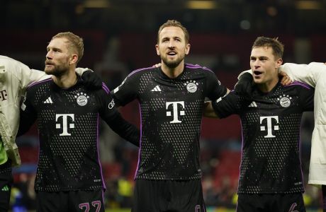 From left: Bayern's Raphael Guerreiro, Bayern's Harry Kane, and Bayern's Joshua Kimmich celebrate after the group A Champions League soccer match between Manchester United and Bayern Munich at the Old Trafford stadium in Manchester, England, Tuesday, Dec. 12, 2023. Bayern won 1-0. (AP Photo/Dave Thompson)