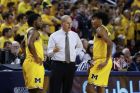 Michigan head coach John Beilein talks with Zavier Simpson, left, and Eli Brooks in the first half of an NCAA college basketball game against Indiana in Ann Arbor, Mich., Sunday, Jan. 6, 2019. (AP Photo/Paul Sancya)