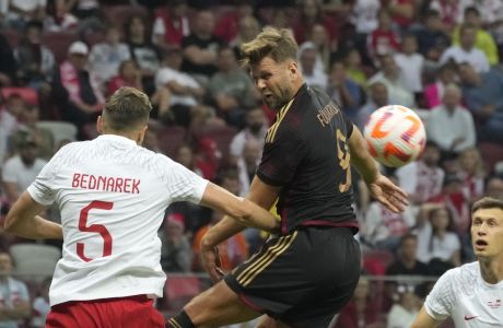 Poland' Jan Bednarek, left, challenges for the ball with Germany's Niclas Fullkrug during the international friendly soccer match between Poland and Germany at the Narodowy stadium in Warsaw, Poland, Friday, June 16, 2023. (AP Photo/Czarek Sokolowski)