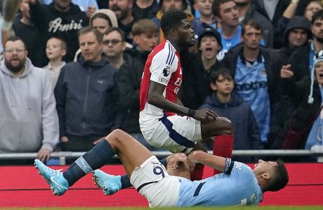 Manchester City's Rodri is injured next to Arsenal's Thomas Partey during the English Premier League soccer match between Manchester City and Arsenal at the Etihad stadium in Manchester, England, Sunday, Sept. 22, 2024. (AP Photo/Dave Thompson)