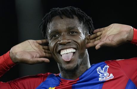 Crystal Palace's Wilfried Zaha celebrates after he scored his side's first goal during the English Premier League soccer match between Crystal Palace and Brighton, at Selhurst Park, London, Monday, Sept. 27, 2021. (AP Photo/Matt Dunham)