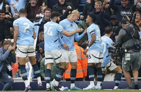 Manchester City's Erling Haaland, center, celebrates after scoring his side's opening goal during the English Premier League soccer match between Manchester City and Arsenal at the Etihad stadium in Manchester, England, Sunday, Sept. 22, 2024. (AP Photo/Dave Thompson)