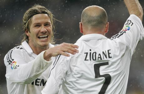 FILE - This is a Sunday, Jan. 15, 2006 file photo of Real Madrid's David Beckham, left, as he congratulates  goalscorer Zinedine Zidane  during their Spanish league soccer match against Sevilla  at the Santiago Bernabeu Stadium in Madrid, Spain.  David Beckham is retiring from soccer after the season, ending a career in which he become a global superstar since starting his career at Manchester United. The 38-year-old Englishman recently won a league title in a fourth country with Paris Saint-Germain. He said in a statement Thursday May 16, 2013  he is "thankful to PSG for giving me the opportunity to continue but I feel now is the right time to finish my career, playing at the highest level." (AP Photo/Bernat Armangue, File)