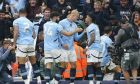 Manchester City's Erling Haaland, center, celebrates after scoring his side's opening goal during the English Premier League soccer match between Manchester City and Arsenal at the Etihad stadium in Manchester, England, Sunday, Sept. 22, 2024. (AP Photo/Dave Thompson)