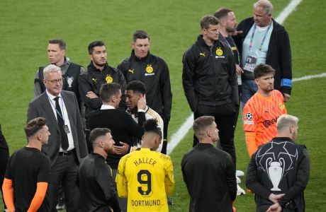 Real Madrid's Jude Bellingham, center, right, speaks with a Borussia Dortmund official at the end of the Champions League final soccer match between Borussia Dortmund and Real Madrid at Wembley stadium in London, Saturday, June 1, 2024. Real Madrid won 2-0. (AP Photo/Alastair Grant)