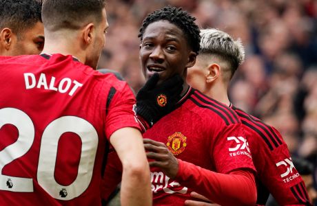 Manchester United's Kobbie Mainoo, centre, celebrates with teammates after scoring his side's second goal during the English Premier League soccer match between Manchester United and Liverpool at the Old Trafford stadium in Manchester, England, Sunday, April 7, 2024. (AP Photo/Dave Thompson)