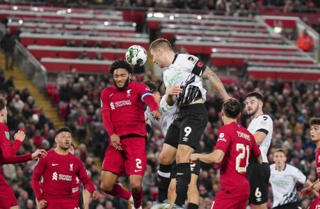 James Collins of Derby County, centre right, heads the ball past Joe Gomez of Liverpool, centre left, during the English League Cup soccer match between Liverpool and Derby County, at Anfield Stadium, in Liverpool, England, Wednesday Nov. 9, 2022. (AP Photo/Jon Super)