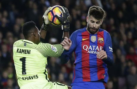 FC Barcelona's Gerard Pique, right, duels for the ball against Malaga's goalkeeper Carlos Kameni, during the Spanish La Liga soccer match between FC Barcelona and Malaga at the Camp Nou in Barcelona, Spain, Saturday, Nov. 19, 2016. (AP Photo/Manu Fernandez)