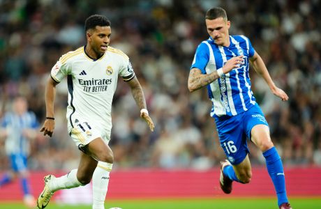 Real Madrid's Rodrygo, left, challenges for the ball with Alaves' Rafa Marin during the Spanish La Liga soccer match between Real Madrid and Deportivo Alaves at the Santiago Bernabeu stadium in Madrid, Spain, Tuesday, May 14, 2024. (AP Photo/Jose Breton)